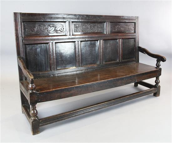 An 18th century oak settle, W.5ft 11in. D.1ft 9.5in. H.3ft 7in.